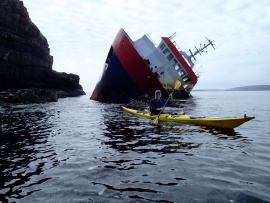 Kayaking past the wreck of a fishing trawler on the west side of Rum.